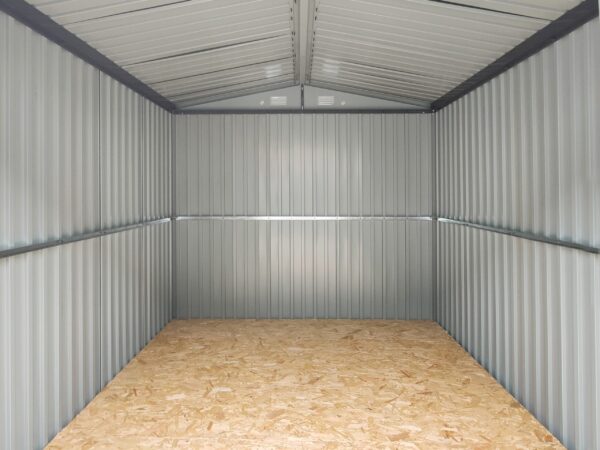 A view of the inside of the premium shed as seen from the doorway. The walls are a pale grey, the floor is a gold-shade of plywood and the brace bars are a dark grey