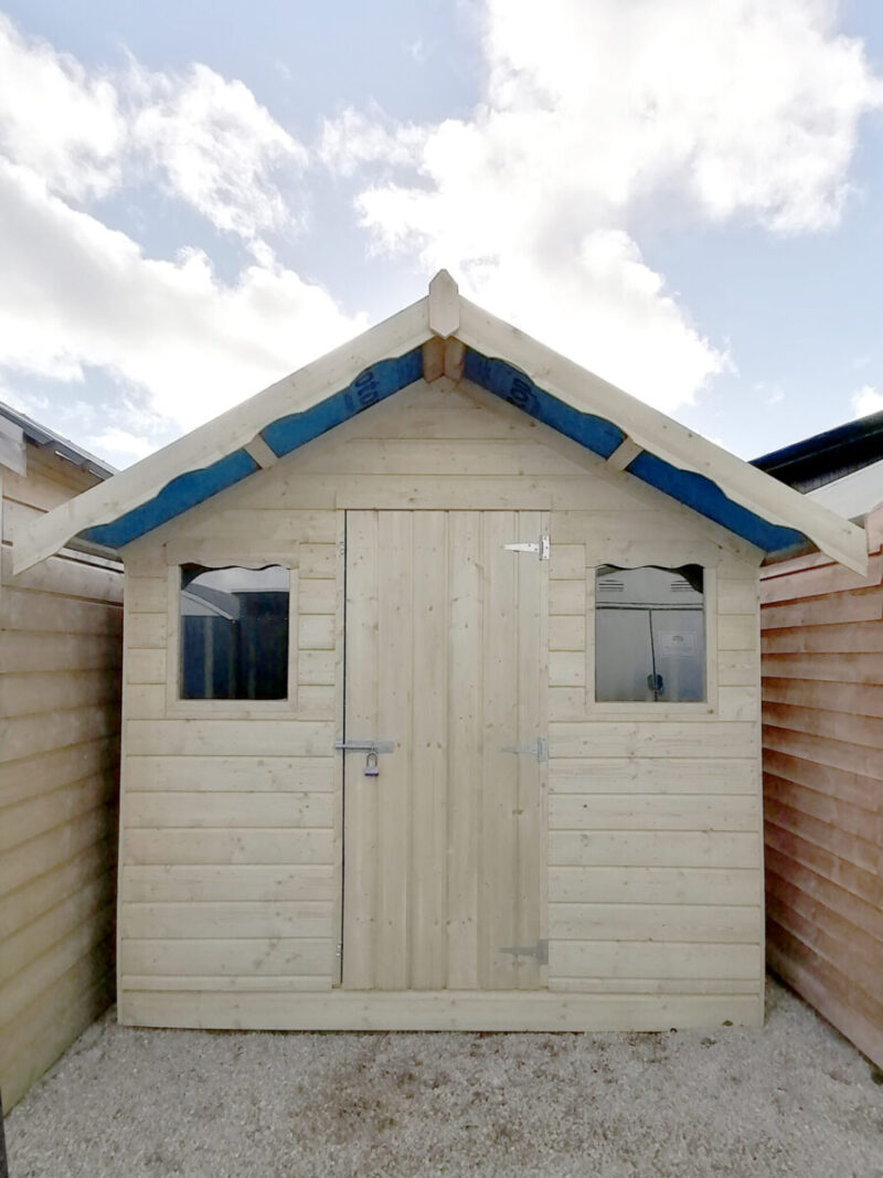 An exterior view of the Overhang wooden shed as seen in. aportrait orientation with lots of blue sky above the shed