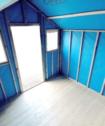 The blue interior of the overhang shed. The outside is bright and light spills into this shed from a low angle