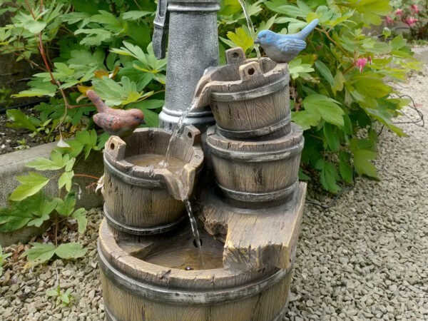 The Bird Pump Water Feature against a wooden shed
