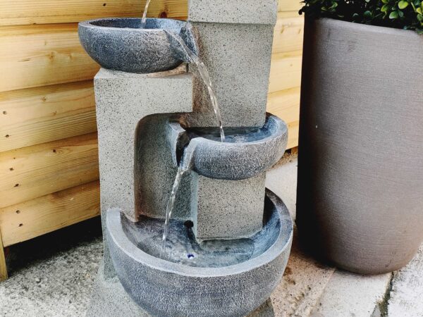 The Bowls Water Feature against a wooden shed