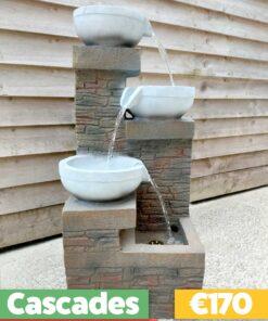 The Cascades Water Feature against a wooden shed