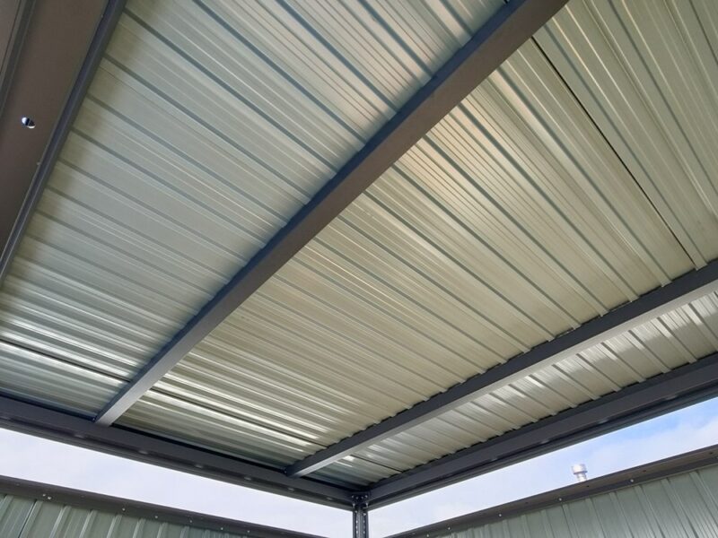 A view of the reinforced roof. It is a pale grey sheet with three thick, dark-grey bars supporting it.