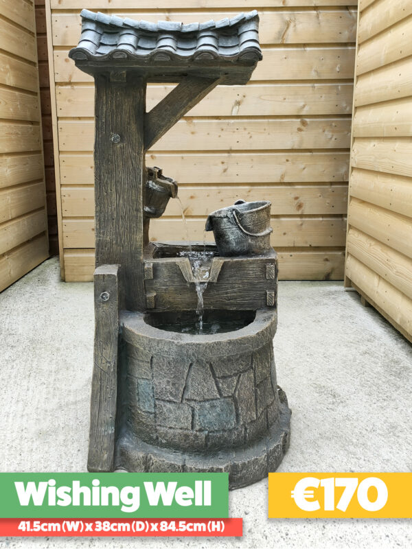 The Wishing Well water feature on the balcony of a wooden chalet shed. The wishing well has an awning above it and a bucket on a rope to the side