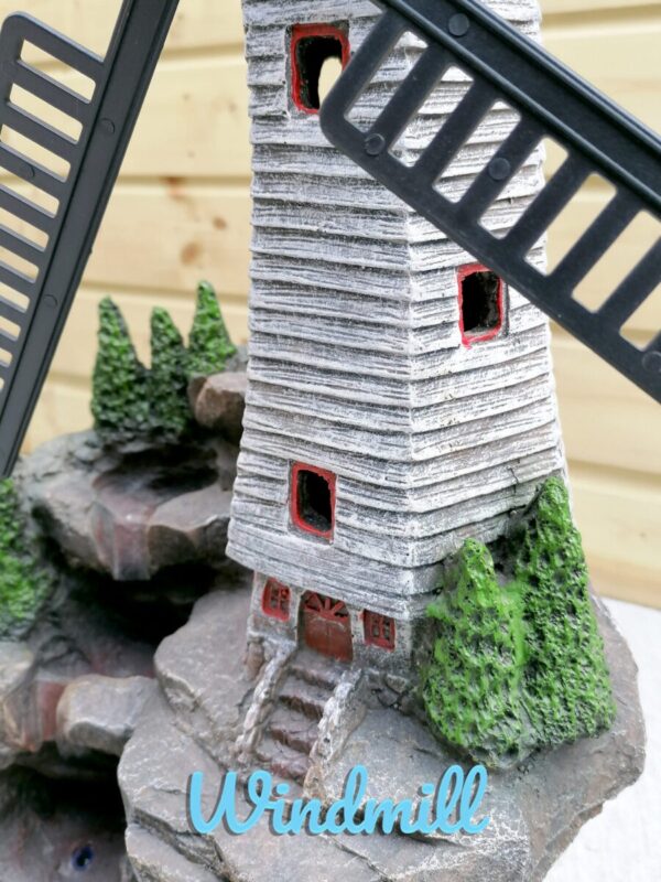 A close up, macro detail of the base of the windmill water feature. The steps up to the door and the small painted details are cute and clean.