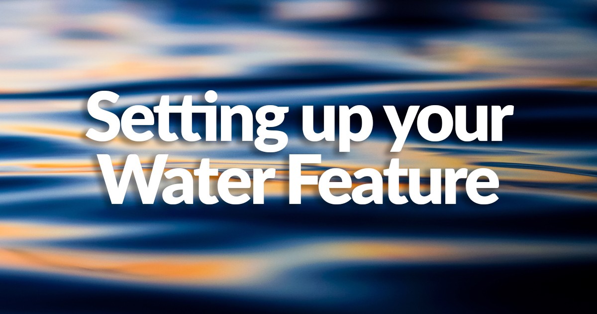 An orange and blue sunset over a still body of water with the words 'setting up your water feature' written on top