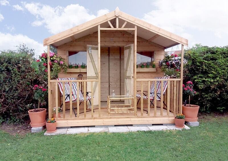 A wooden Chalet Shed in Dublin on a lawn with large bushes either side