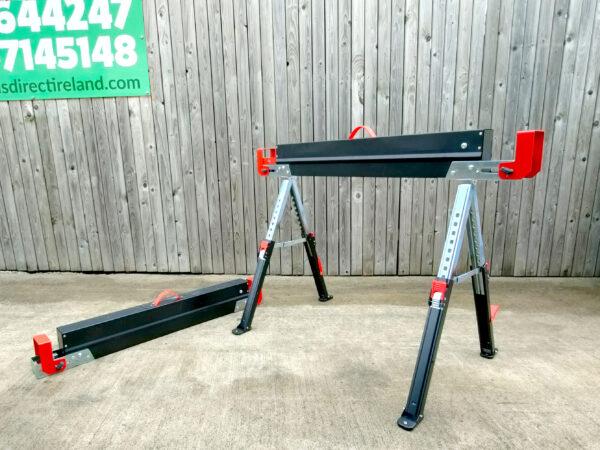 Two saw horses side-by-side against the sheds direct ireland logo. One of the Saw Horses is fully extended the other is lies on the ground, about 6