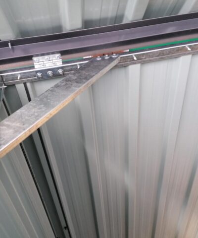 The internal brace bar of the 3-bin store. It's a shiny, silver colour and it creates a right angled triangle with the edges of the unit