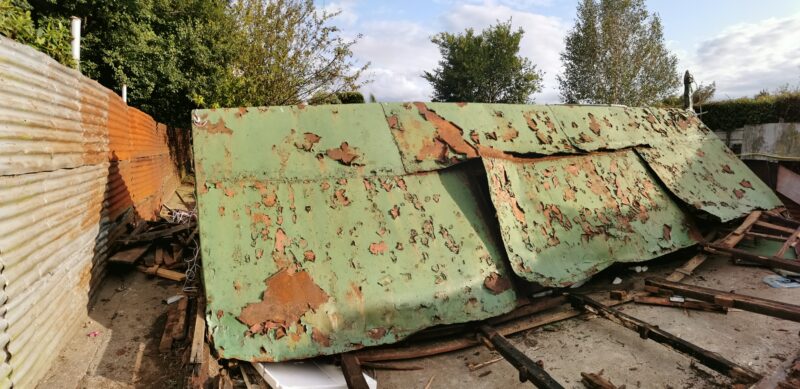 The rusted green shed in the previous image now crumped in a pile having being felled by a hurley.