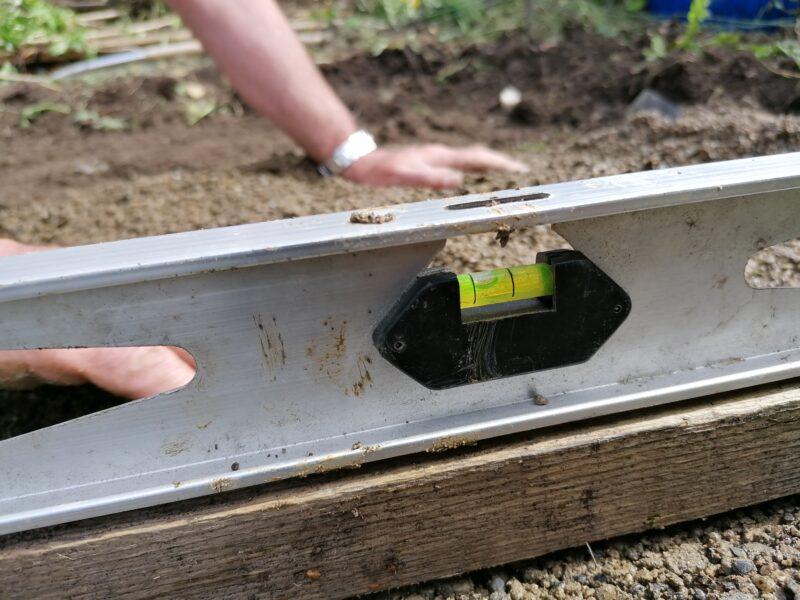 a lime coloured spirit level shows a perfectly centred bubble in the middle of it, signifying that the base is appropriately level