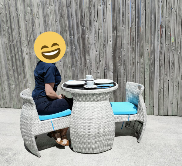 a woman sitting at the table and chairs set waiting for her food