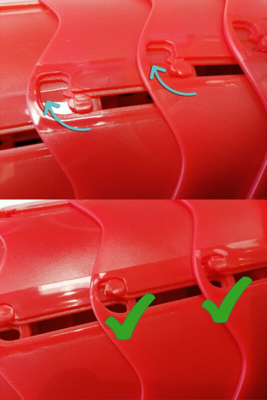 The red 'teeth' of the pop up stool being shown clicking into place, via a rotation of the handle upwards 