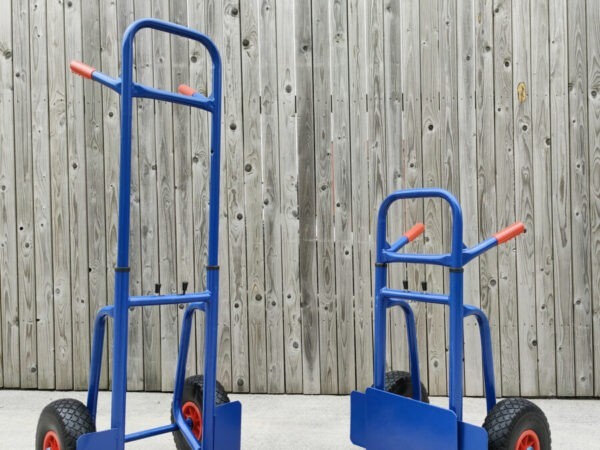 Two of the blue hand trucks with extendable backs side by side. The are both at 45 degree angles, pointing inwards towards the camera. The one on the left is fully extended. The one on the right is compacted.
