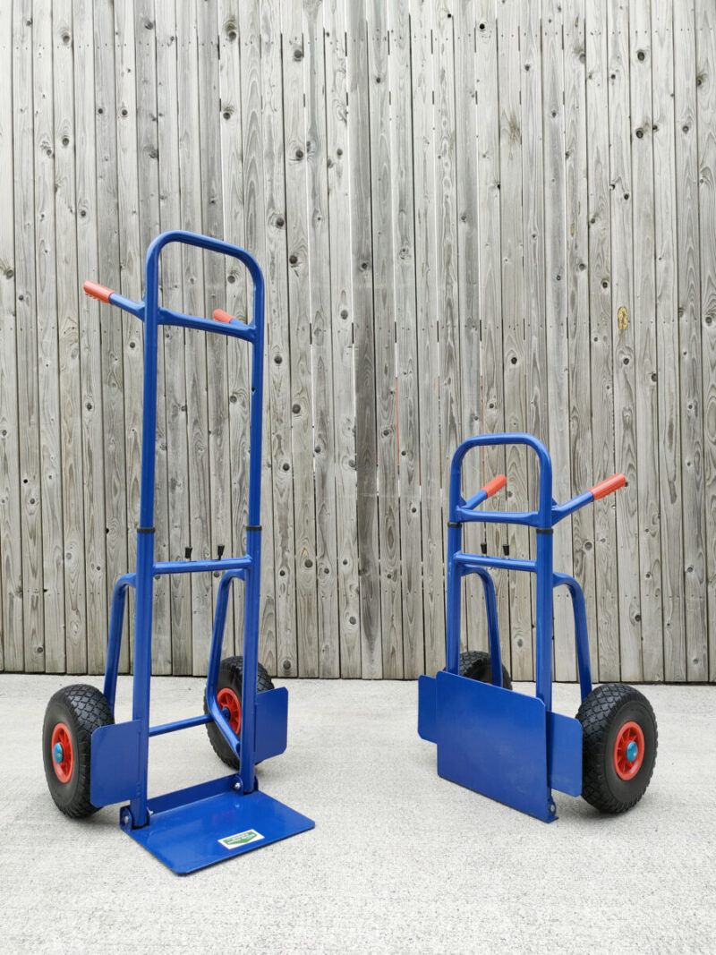 Two of the blue hand trucks with extendable backs side by side. The are both at 45 degree angles, pointing inwards towards the camera. The one on the left is fully extended. The one on the right is compacted.