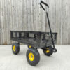 The black mesh cart from Sheds Direct Ireland against a wooden wall