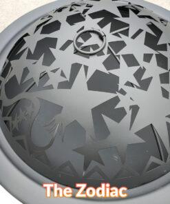 A top view of the motif on the lid of the zodiac fire pit. There are various different sized stars, a dragon's tail and some small circle on it. It's a satisfyingly nice matte black