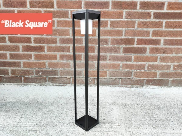 The Black Square LED garden light from sheds direct ireland. It is a tall, ractangular shape. There is a tubular light protruding downwards from the inside of the top part and it is an opaque white colour. The unit is made of whin black bars.