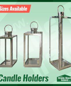 The three sizes of the lantern-style candles holders side by side on a green background. They are in order ascending in height.