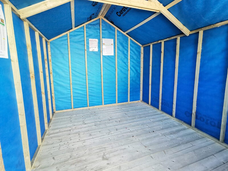 The inside of an 8ft x 8ft barrel board wooden shed which is showing the internal blue membrane up against the side walls