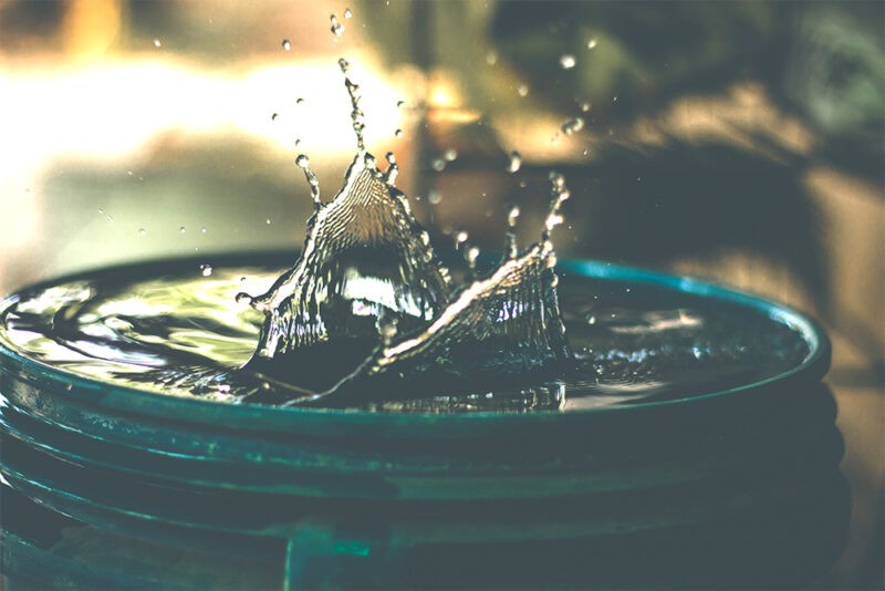 Bucket of water, with a small splash. Having water on hand is essential for Fire Pit Safety