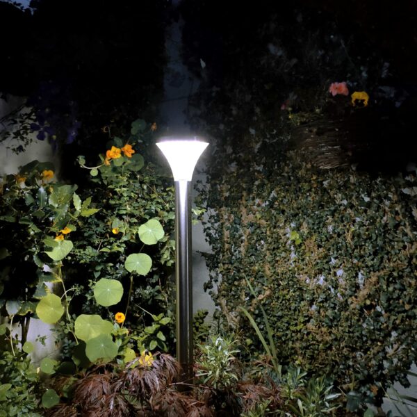 The Silver garden light as seen from a low angle with the perimeter wall in view and the dark-blue night sky visible.