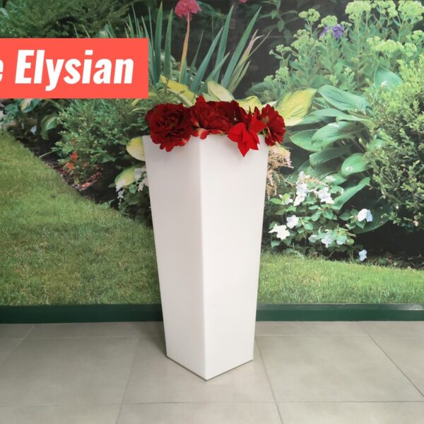 The Elysian Plant pot filled with Poinsettia flowers. It is a tall, white flower pot that is about three times as tall as it is wide. It is more narrow at the base than it is at the top.
