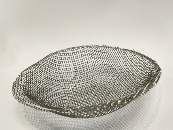 An upside-down silver Mesh dome for a camping stove on a white backdrop