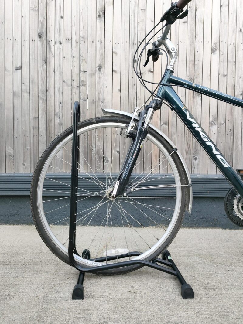 A close up, side view of the bike stand with a bicycle parked into it.