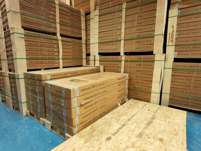 Boxes of our steel sheds alongside sheets of plywood for scale