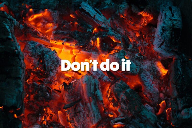 a close up of coal embers burning bright red and orange with the words 'don't do it' written on top in white text