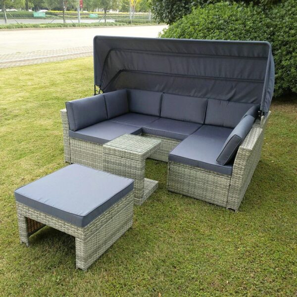 The outdoor rattan garden sofa set from sheds direct Ireland outside on a green lawn. The unit it a rattan, light-brown colour and the cushions and awning are a dark grey colour.