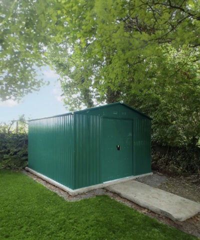 The Colossus shed in green in a garden, covered by a willow tree