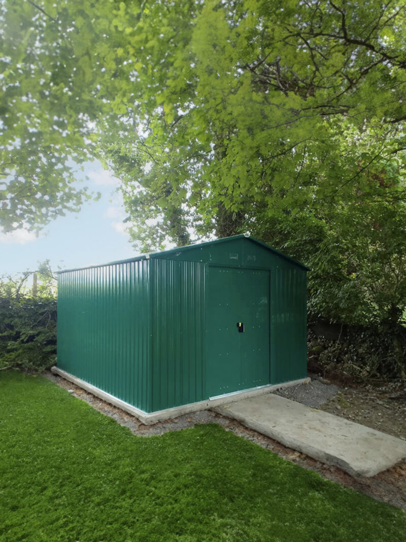 The Colossus shed in green in a garden, covered by a willow tree