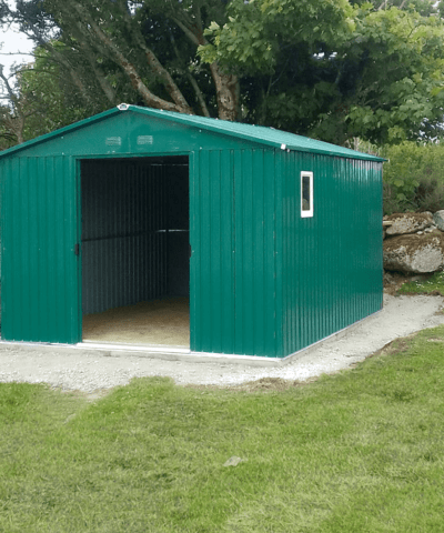 The Colossus shed in a large garden. There is a large tree behind it. Both doors are open and the shed is dark inside.