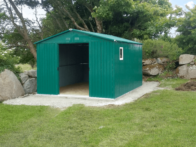 The Colossus shed in a large garden. There is a large tree behind it. Both doors are open and the shed is dark inside.