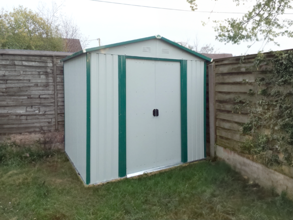 8ft x 6ft Steel Garden Shed in off-white in the corner of a garden