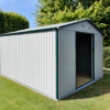 An off-white version of the 9ft x 10ft steel garden shed sitting in a grassy garden. There are large bushes in the back of the scene