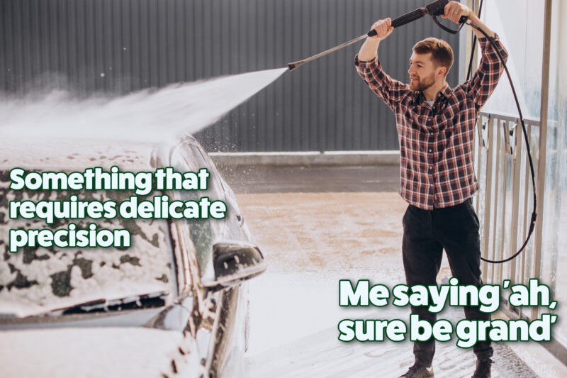 Young man washing his car at carwash