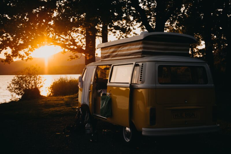 A campervan by a lake at sunset