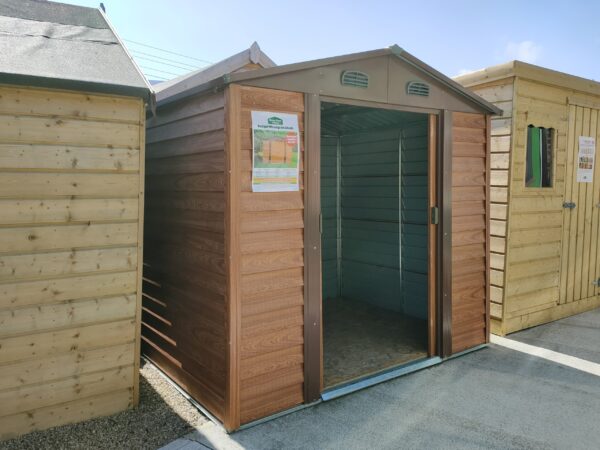 The Budget woodgrain shed as seen from outisde. The doors are open and there are two wooden sheds either side of it.