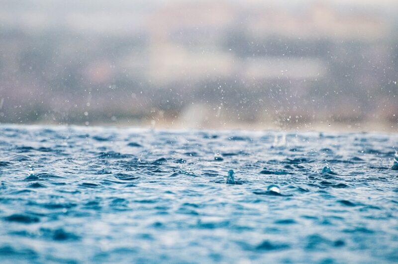 A picture of a puddle with raindrops falling into it