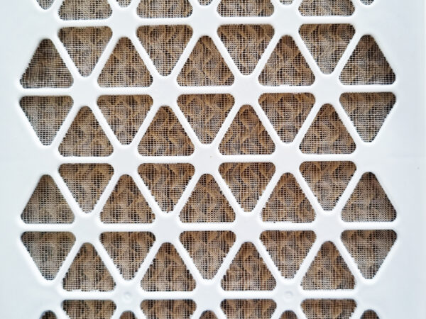 A detailed look at the filter at the back of the unit. It's a cream plastic, with diamonds cut into it. Beyond this there is a faded grey fabric.