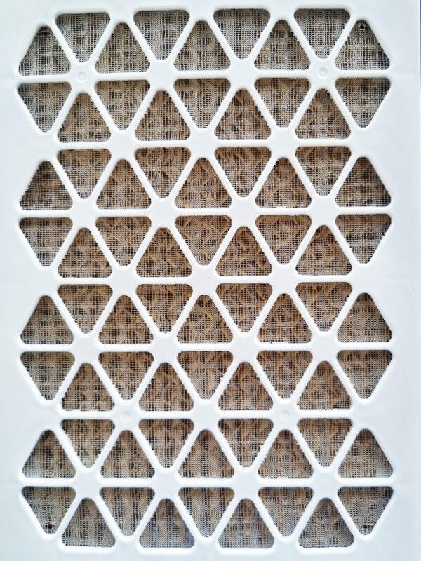 A detailed look at the filter at the back of the unit. It's a cream plastic, with diamonds cut into it. Beyond this there is a faded grey fabric.