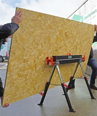 two men loading a sheet of wood onto it