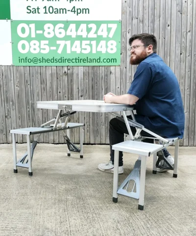 A man sitting on one of the seats at the picnic table