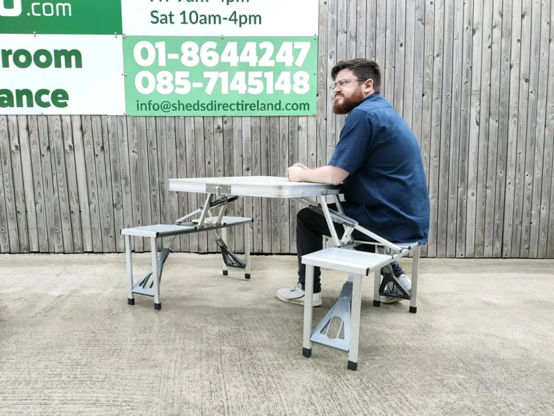 A man sitting on one of the seats at the picnic table