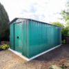 The 6ft wide x 12ft deep steel garden shed in green in a garden