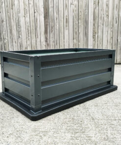 picture of a raised garden bed on a concrete floor with wood behind