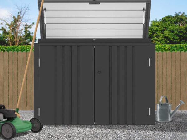 The Carino Storage Unit in a garden. The top door roof is open and there is a lawnmower to the left of it.